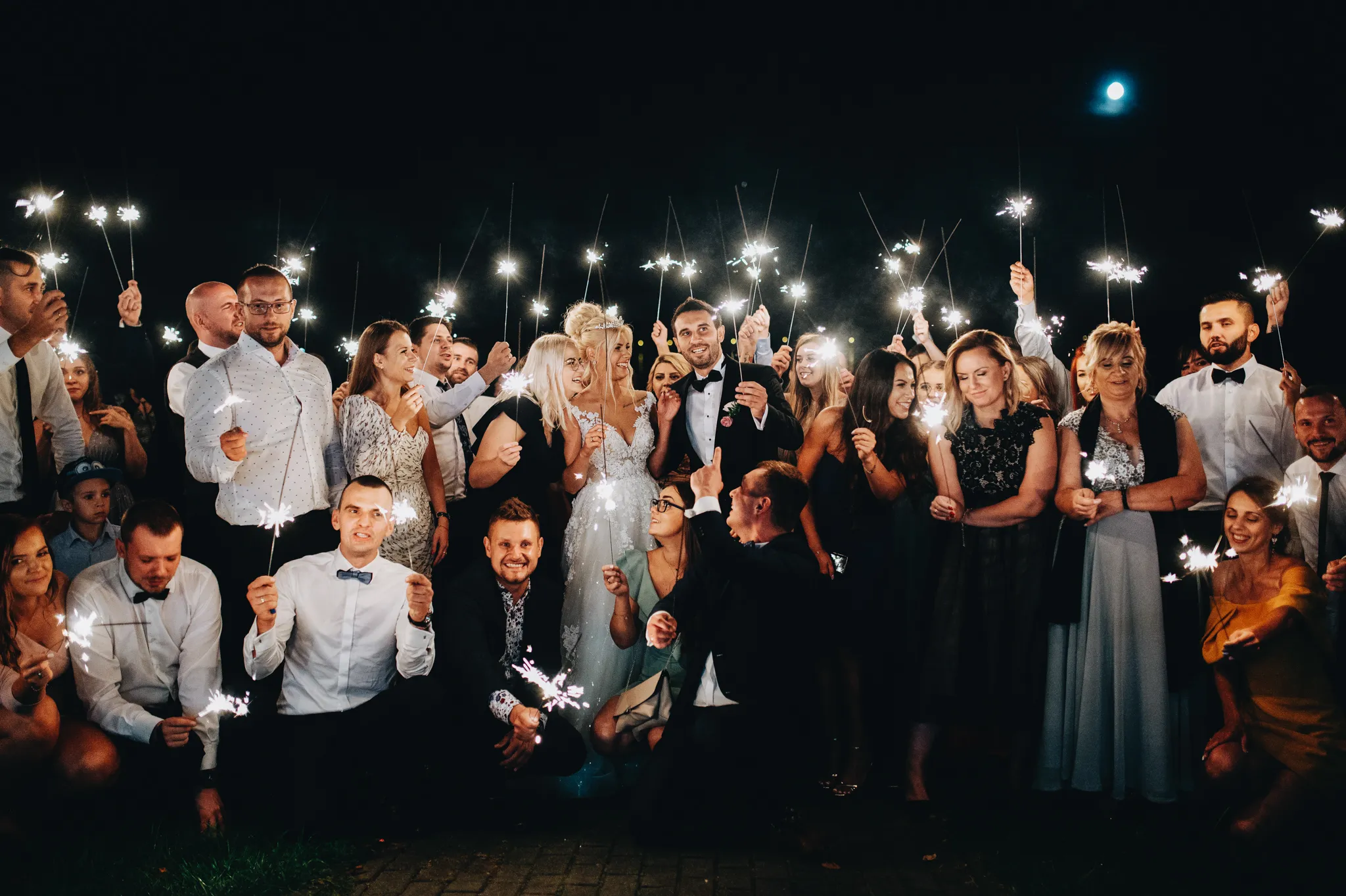 para mloda z goscmiw nocy z zimnymi ogniami na tle jeziora przeczyce